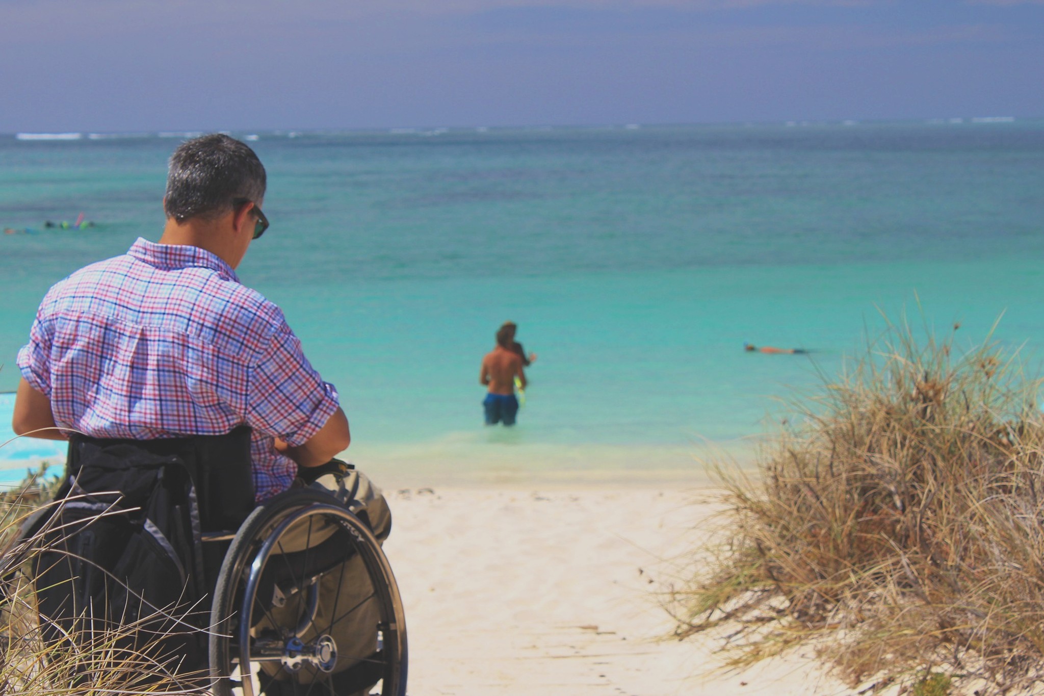 Man on a wheelchair having great day in the beach of Ontario