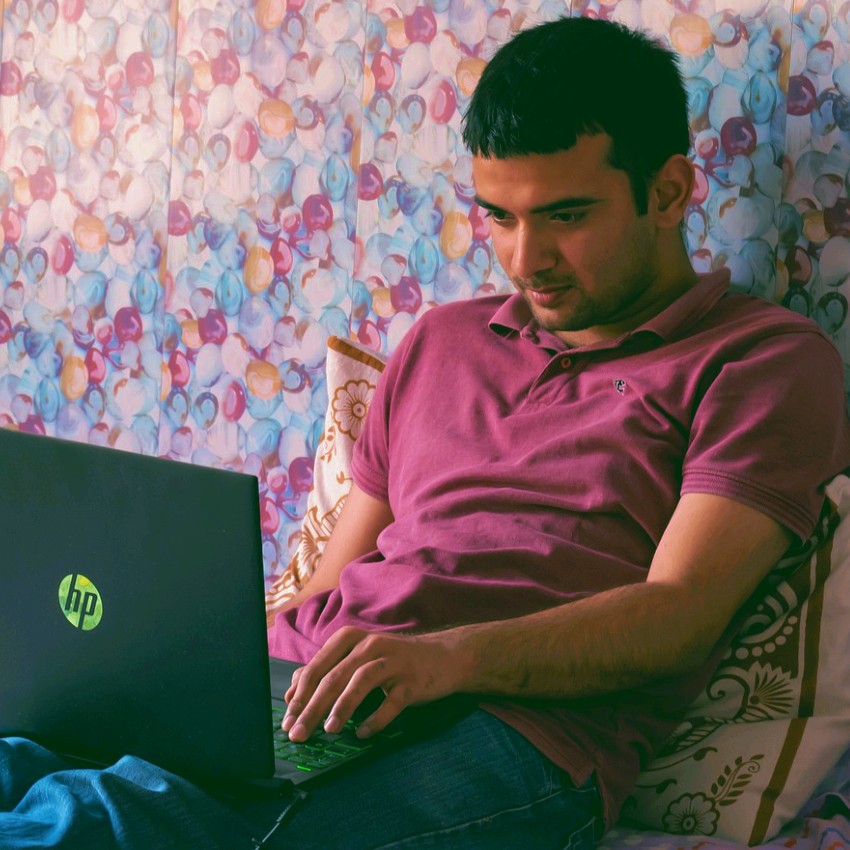 a man looking on his laptop deciding to buy an old house